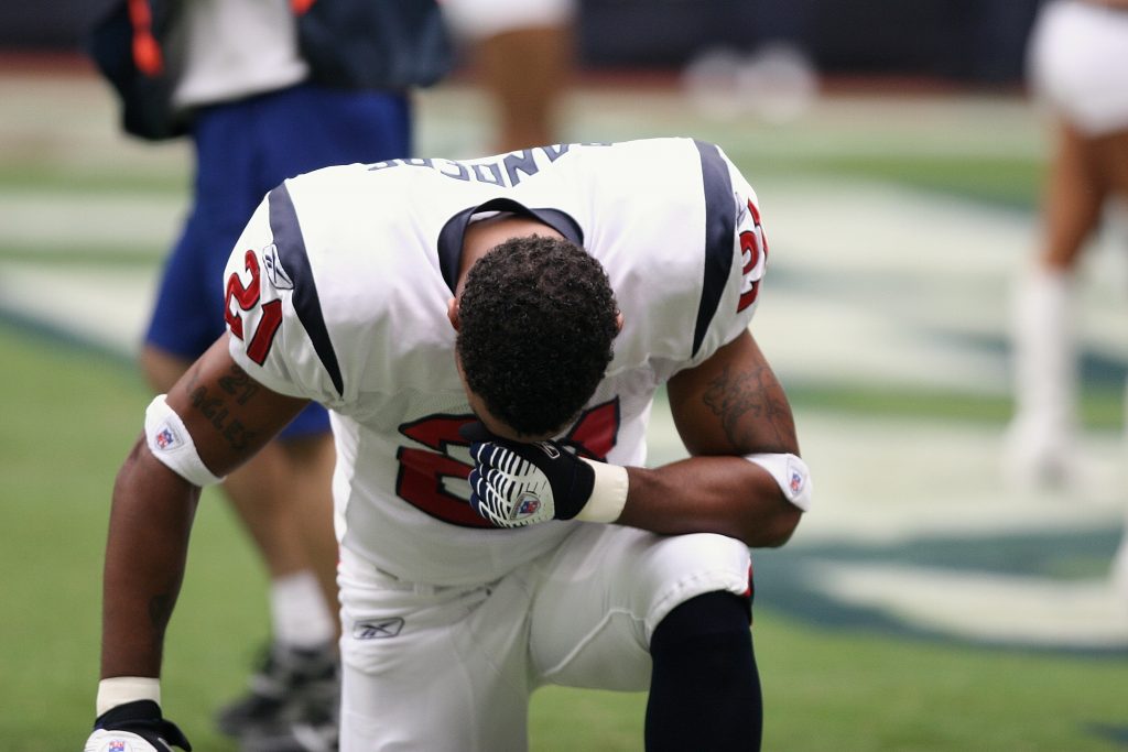 A football player kneeling on the field