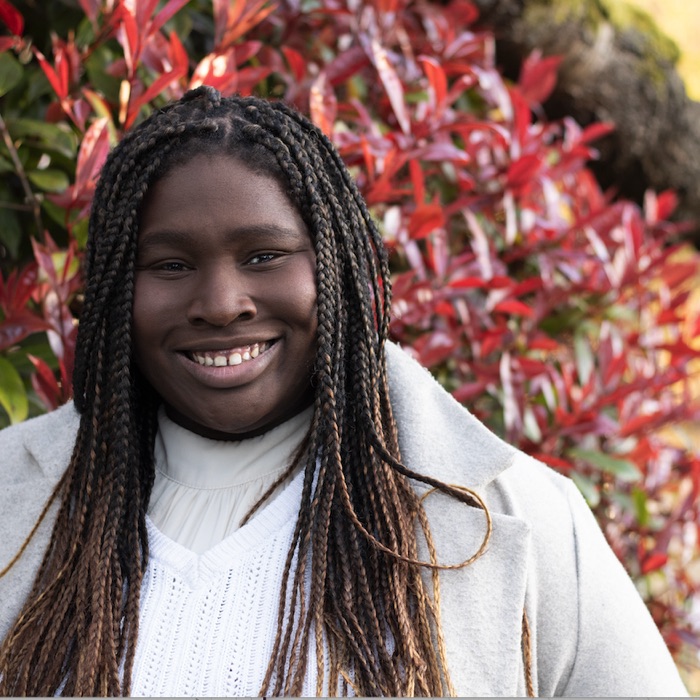 Maddy Devitt smiling in front of red leaves